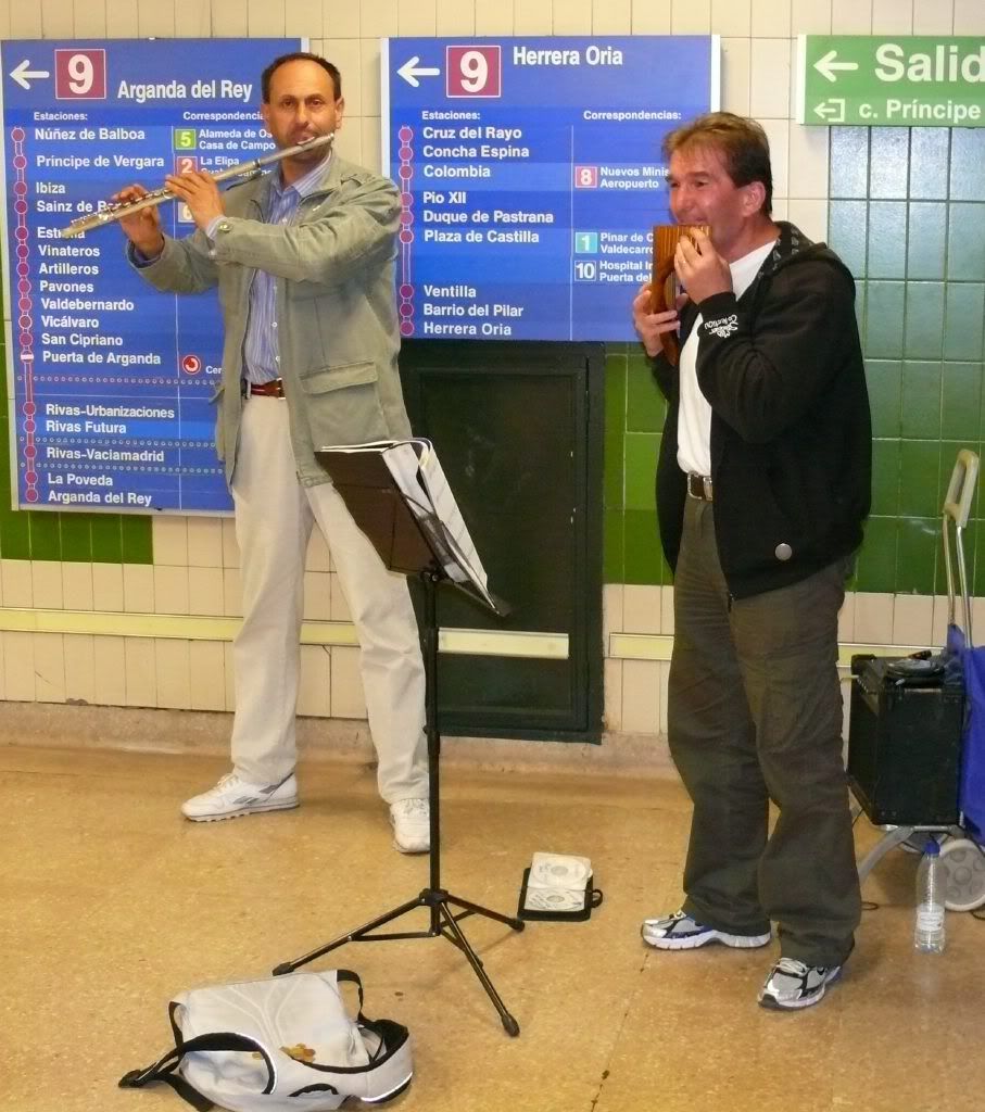 dos musicos en los pasillos del metro, tocando flauta