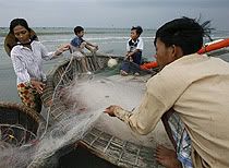 Vietnamese fishermen pack their nets after a day of fishing